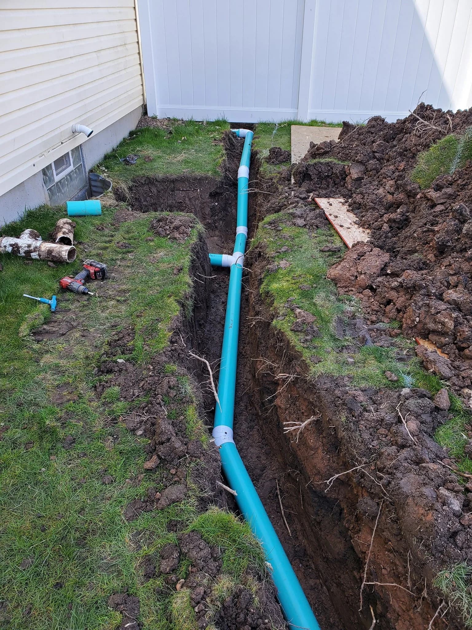 PVC sewer with T-junction and drill in Blasdell foundation trench