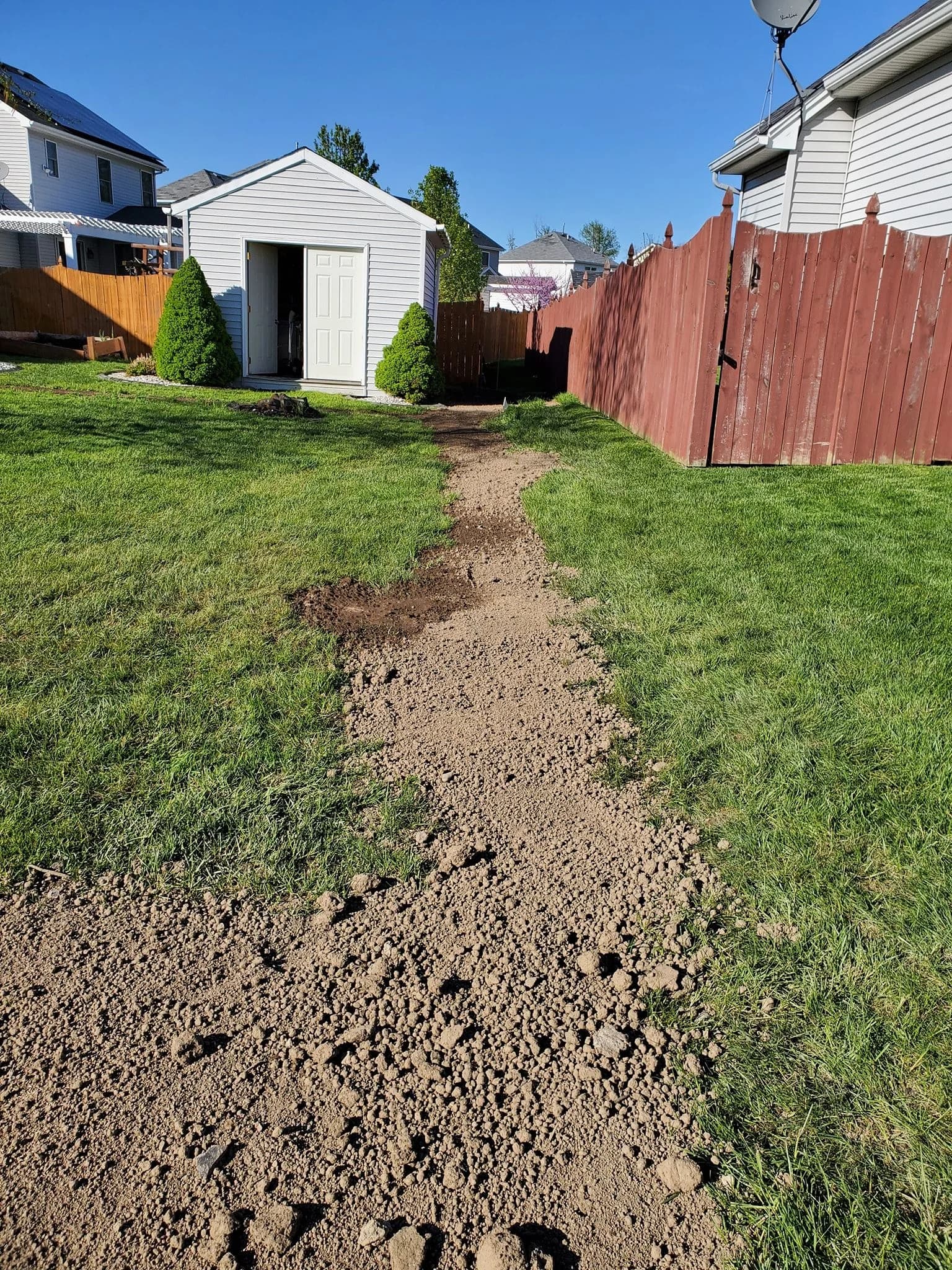 Backfilled trench line to shed in West Seneca backyard along fence
